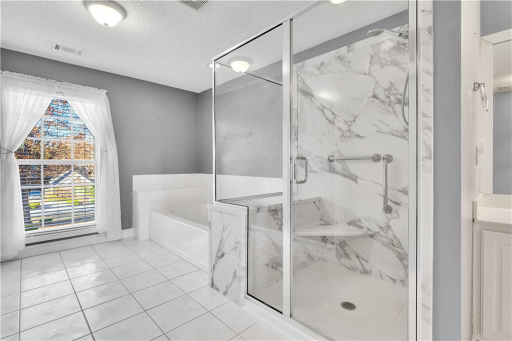 523 Barhams Ridge Drive McDonough, GA 30252 - Photo 34 of 43 a bathroom with a glass shower door and a window