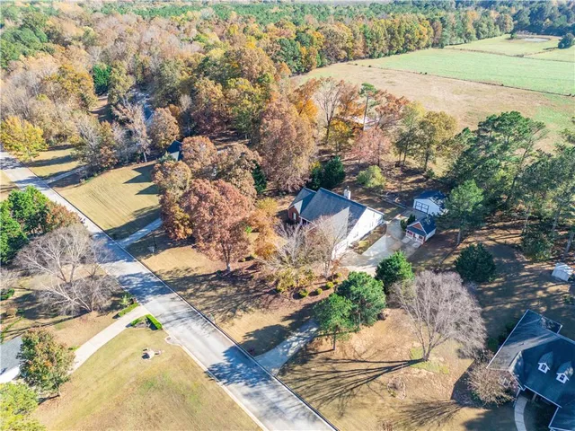 an aerial view of a house with a yard and lake view