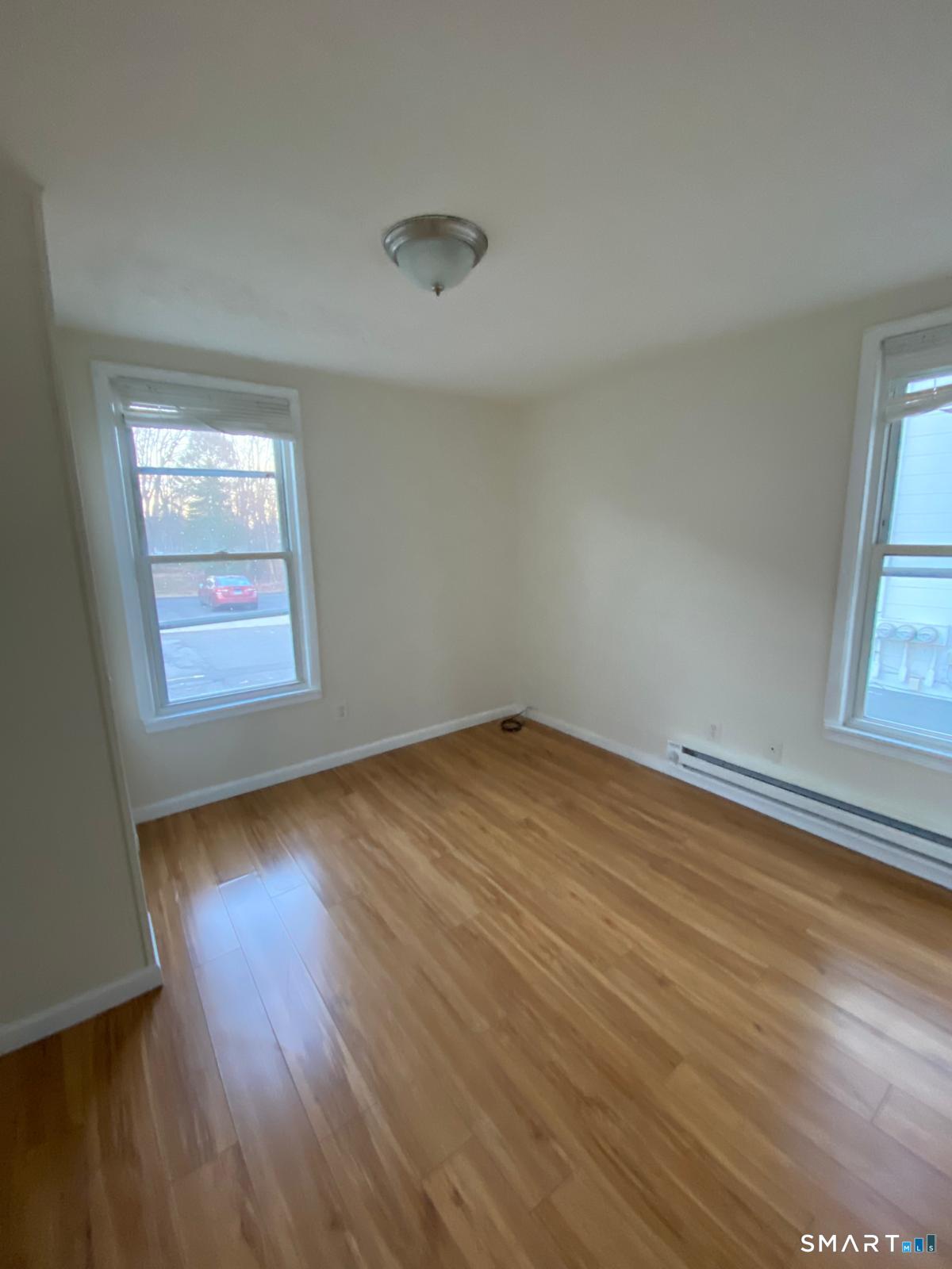 54 North Avenue Meriden, CT 06451 - Photo 2 of 18 an empty room with wooden floor and windows
