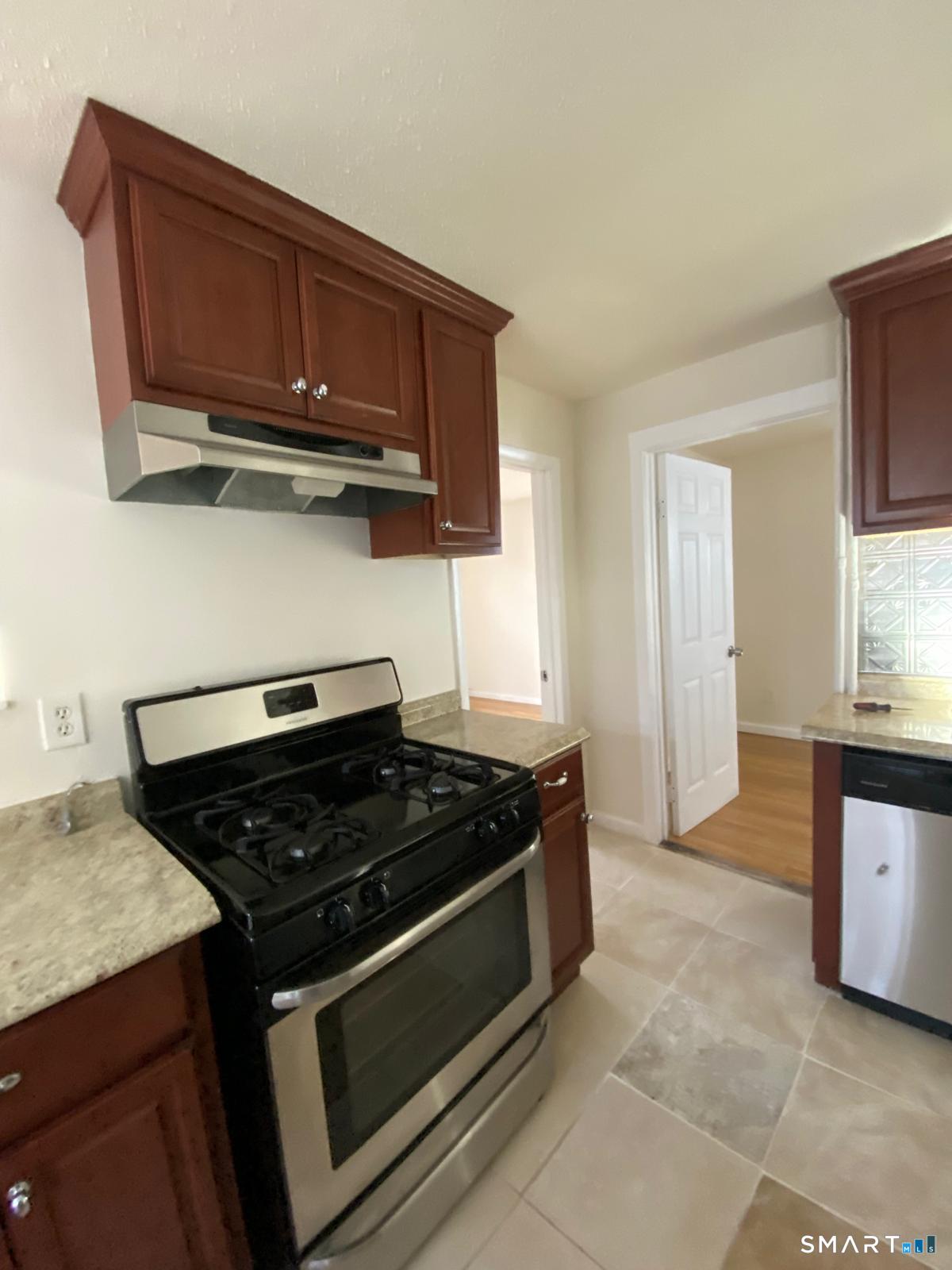 54 North Avenue Meriden, CT 06451 - Photo 6 of 18 a kitchen with stainless steel appliances granite countertop a stove a microwave and cabinets