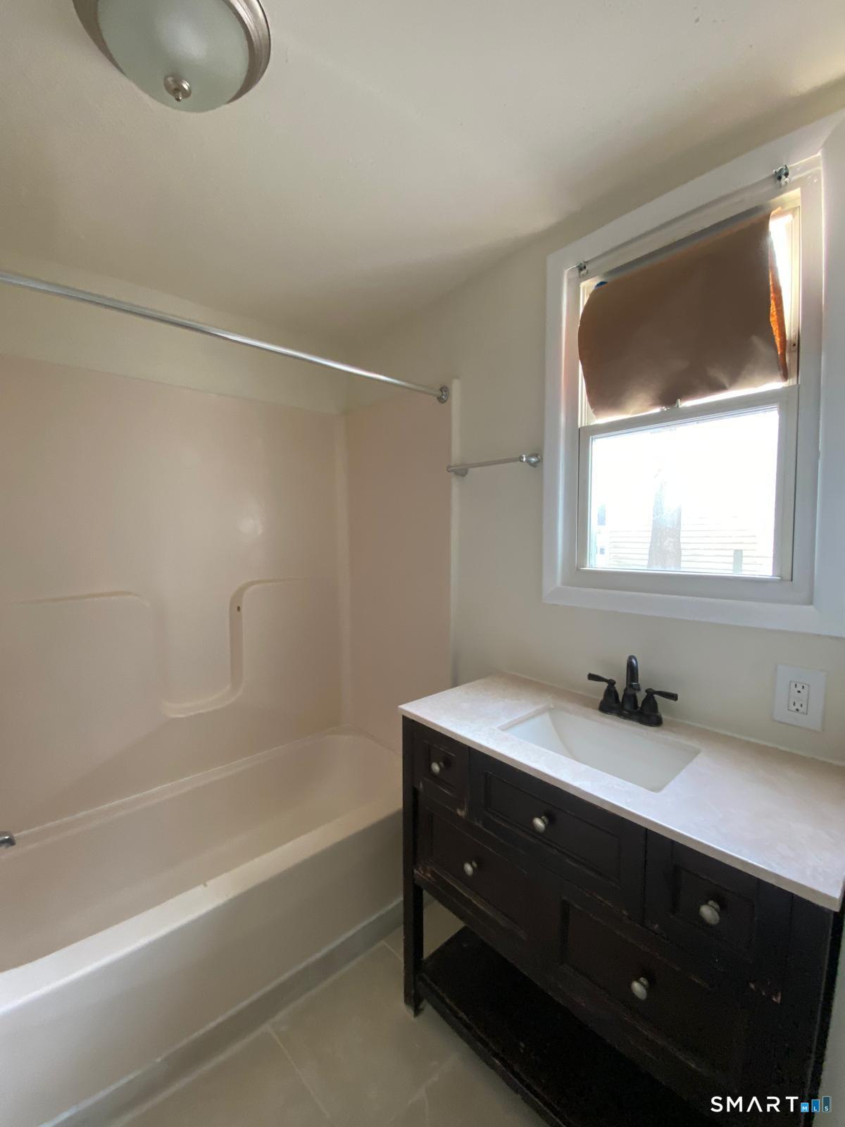 54 North Avenue Meriden, CT 06451 - Photo 9 of 18 a bathroom with a sink vanity tub and a mirror