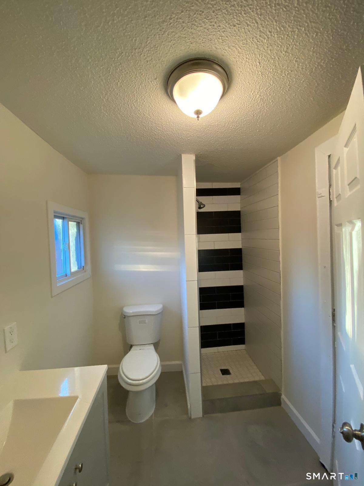 54 North Avenue Meriden, CT 06451 - Photo 10 of 18 a bathroom with a toilet a sink and a shower