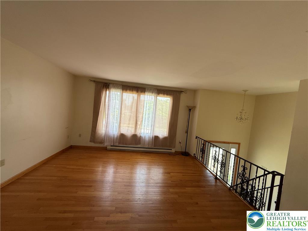 1150 Ridge Avenue Allentown, PA 18102 - Photo 3 of 14 Step into a generously proportioned living area with rich hardwood flooring and a stylish wrought iron railing.