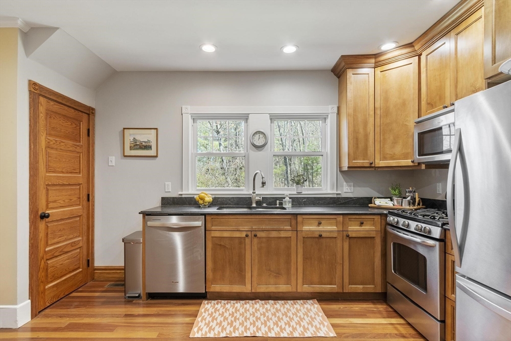 203 Main Street Acton, MA 01720 - Photo 21 of 42 a kitchen with stainless steel appliances granite countertop a stove a sink and a microwave