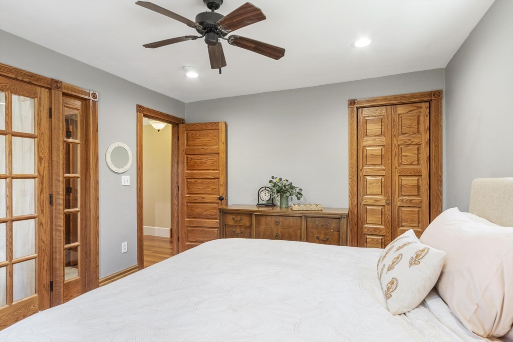 203 Main Street Acton, MA 01720 - Photo 30 of 42 a bedroom with a bed and a chandelier