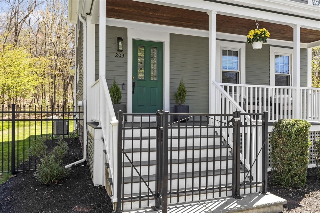 203 Main Street Acton, MA 01720 - Photo 3 of 42 a front view of a house with a iron fence