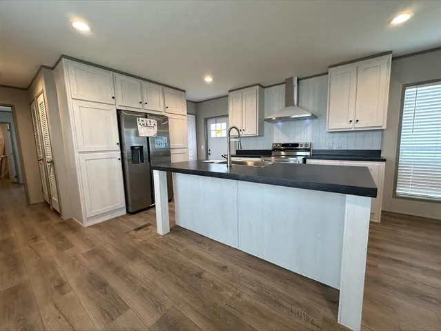 a kitchen with refrigerator a sink and white cabinets