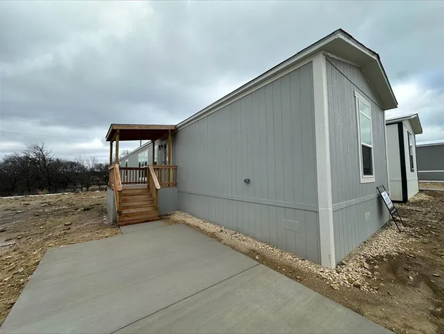 a backyard of a house with basket ball court and wooden fence