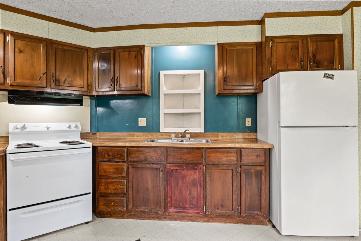 6495 Divider And Natchez Trace Road Camden, TN 38320 - Photo 11 of 31 a kitchen with a stove a refrigerator and cabinets