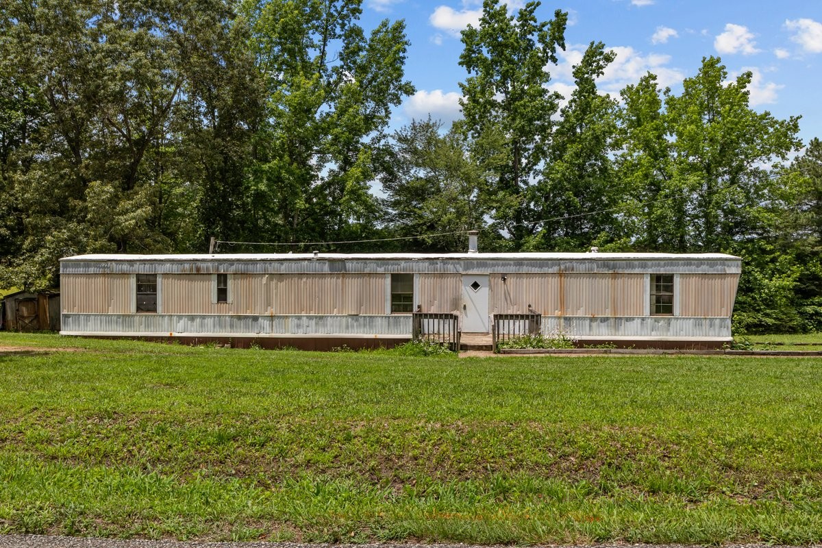 6495 Divider And Natchez Trace Road Camden, TN 38320 - Photo 2 of 31 a white house with a large tree and a yard in front of it