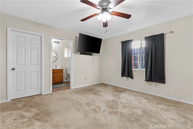 an empty room with fan front door and windows