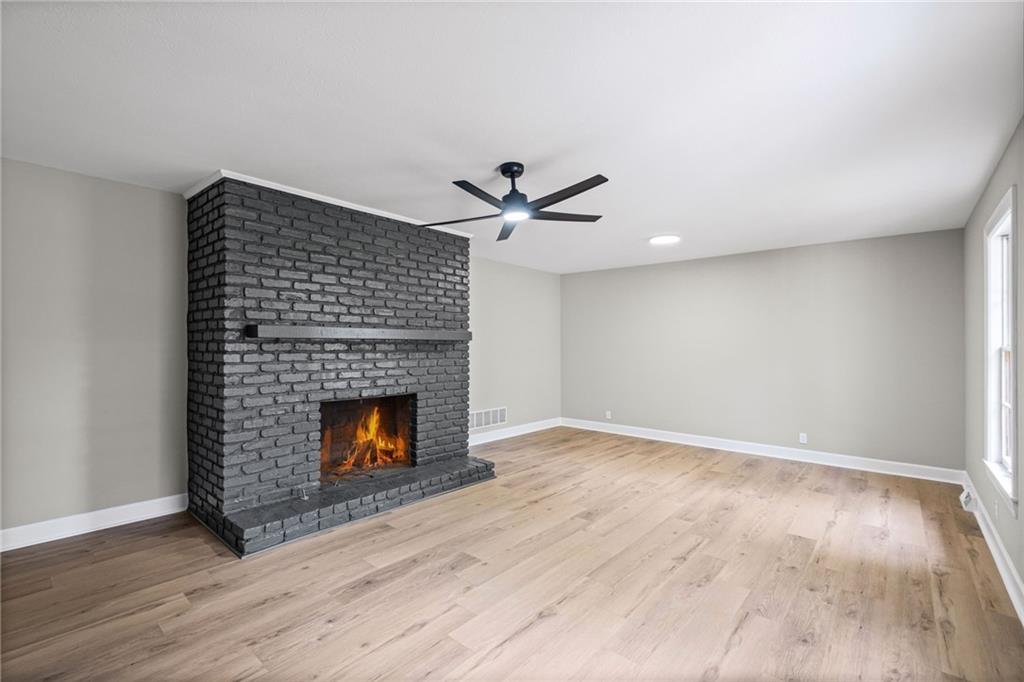7 East Creekview Drive Southwest Rome, GA 30165 - Photo 7 of 43 a view of an empty room with wooden floor fireplace and a window