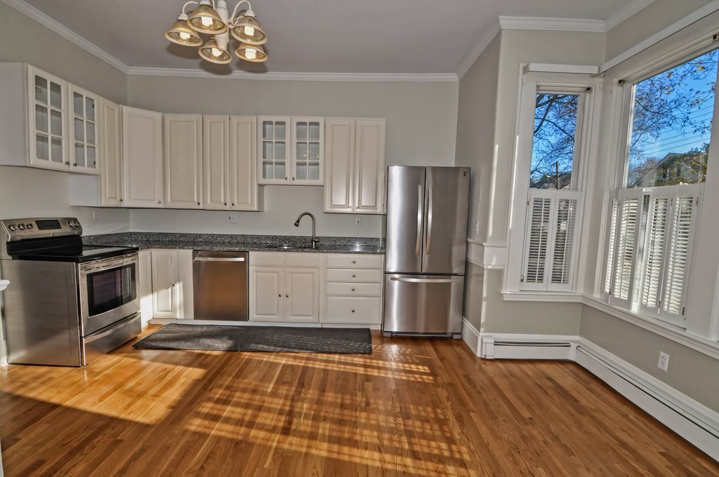 87-89 Pleasant Street Needham, MA 02492 - Photo 11 of 30 a kitchen with stainless steel appliances wooden floor and a refrigerator