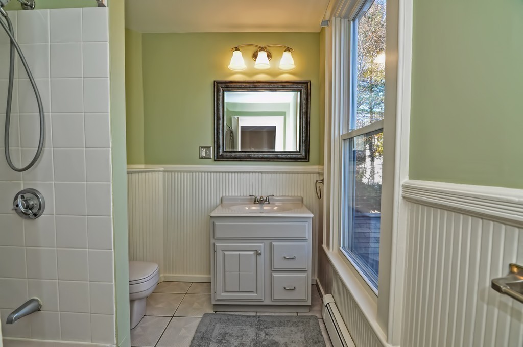 87-89 Pleasant Street Needham, MA 02492 - Photo 15 of 30 a bathroom with a toilet a sink and mirror