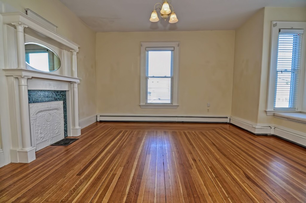 87-89 Pleasant Street Needham, MA 02492 - Photo 18 of 30 a view of an empty room with wooden floor fireplace and a window