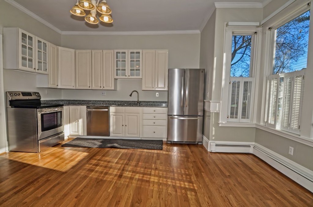 87-89 Pleasant Street Needham, MA 02492 - Photo 8 of 30 a kitchen with stainless steel appliances granite countertop a refrigerator a sink dishwasher a stove and white countertops with wooden floor