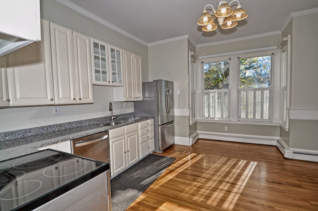 87-89 Pleasant Street Needham, MA 02492 - Photo 10 of 30 a kitchen with stainless steel appliances granite countertop a refrigerator oven a sink dishwasher and white cabinets with wooden floor