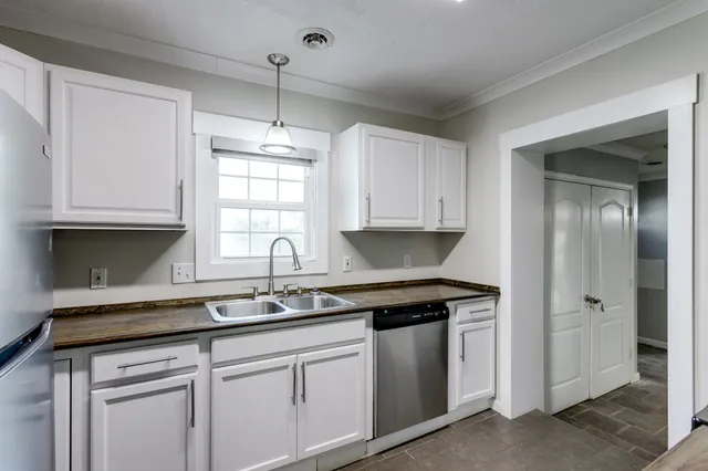 a kitchen with stainless steel appliances a sink stove and refrigerator