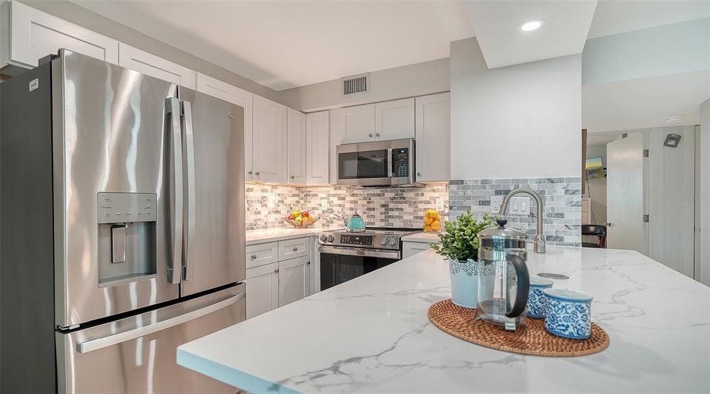 5950 Midnight Pass Road, Unit 201 Sarasota, FL 34242 - Photo 12 of 36 a kitchen with a refrigerator and a stove