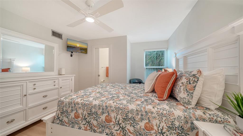 5950 Midnight Pass Road, Unit 201 Sarasota, FL 34242 - Photo 15 of 36 a bedroom with a large bed and a dresser