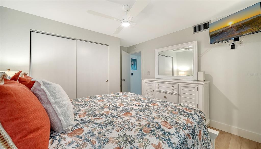5950 Midnight Pass Road, Unit 201 Sarasota, FL 34242 - Photo 17 of 36 a bed room with a bed mirror and vanity