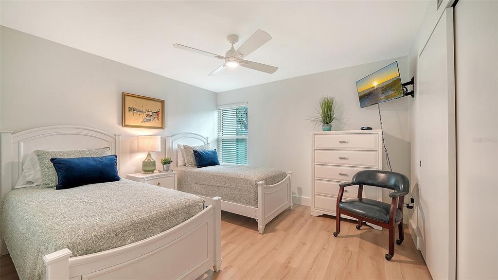 5950 Midnight Pass Road, Unit 201 Sarasota, FL 34242 - Photo 18 of 36 a bedroom with two beds and painting on the wall