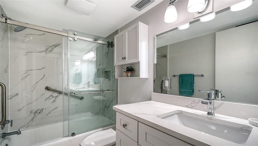 5950 Midnight Pass Road, Unit 201 Sarasota, FL 34242 - Photo 20 of 36 a bathroom with a sink a toilet and shower