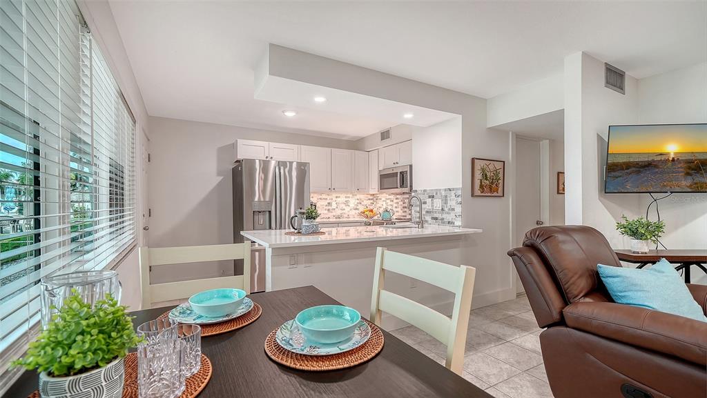5950 Midnight Pass Road, Unit 201 Sarasota, FL 34242 - Photo 9 of 36 a kitchen with a dining table and chairs