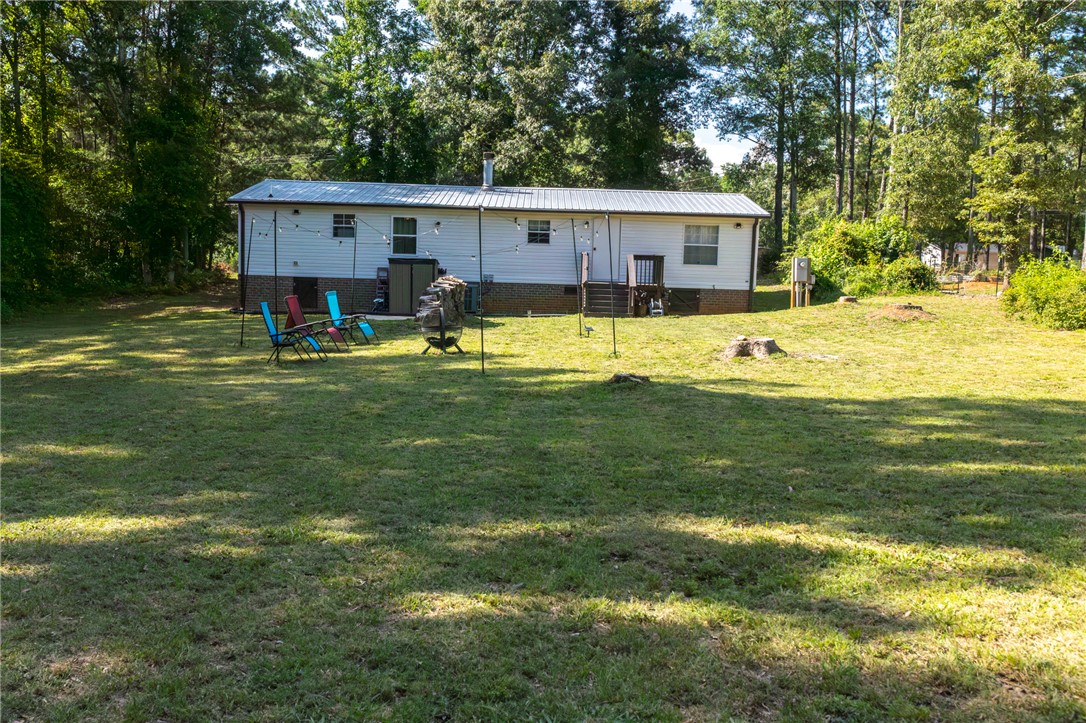 2632 Broadway Lake Road Anderson, SC 29621 - Photo 19 of 20 A spacious, verdant yard provides ample outdoor living space behind a well-maintained home surrounded by mature trees. and Blackberry shrubs