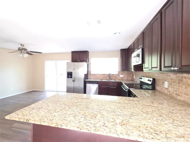 a kitchen with granite countertop a sink and a stove