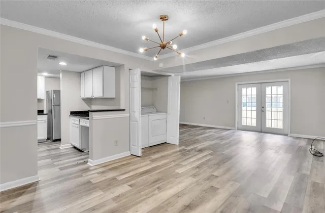a view of an empty room with window and wooden floor