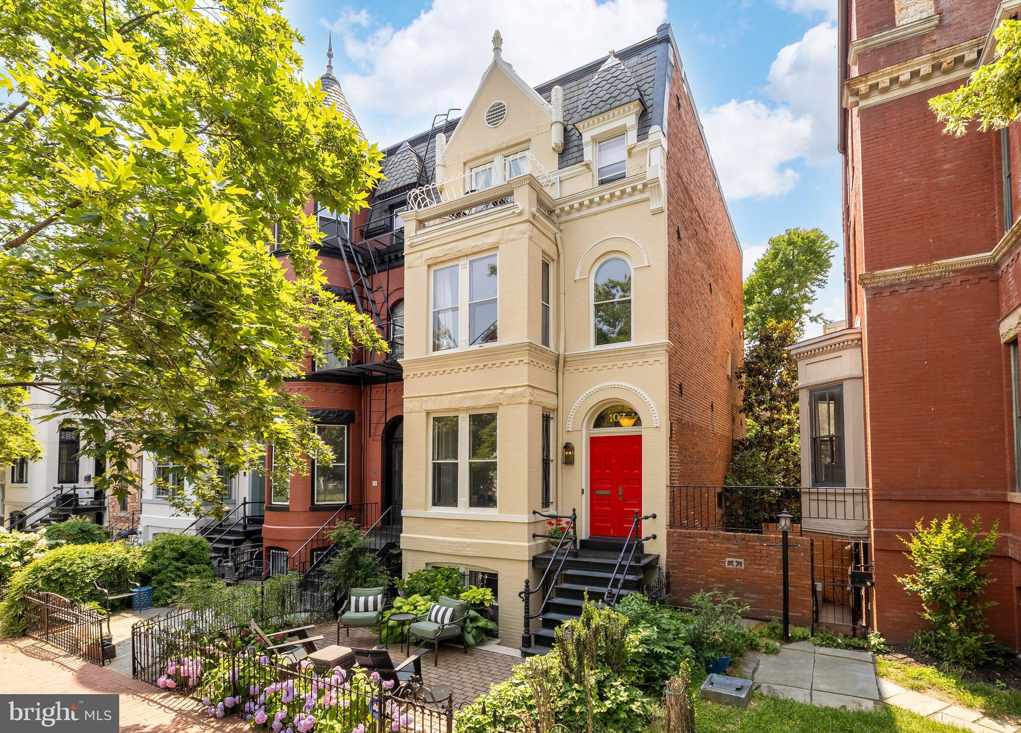 a view of a white house with large windows and a flower garden