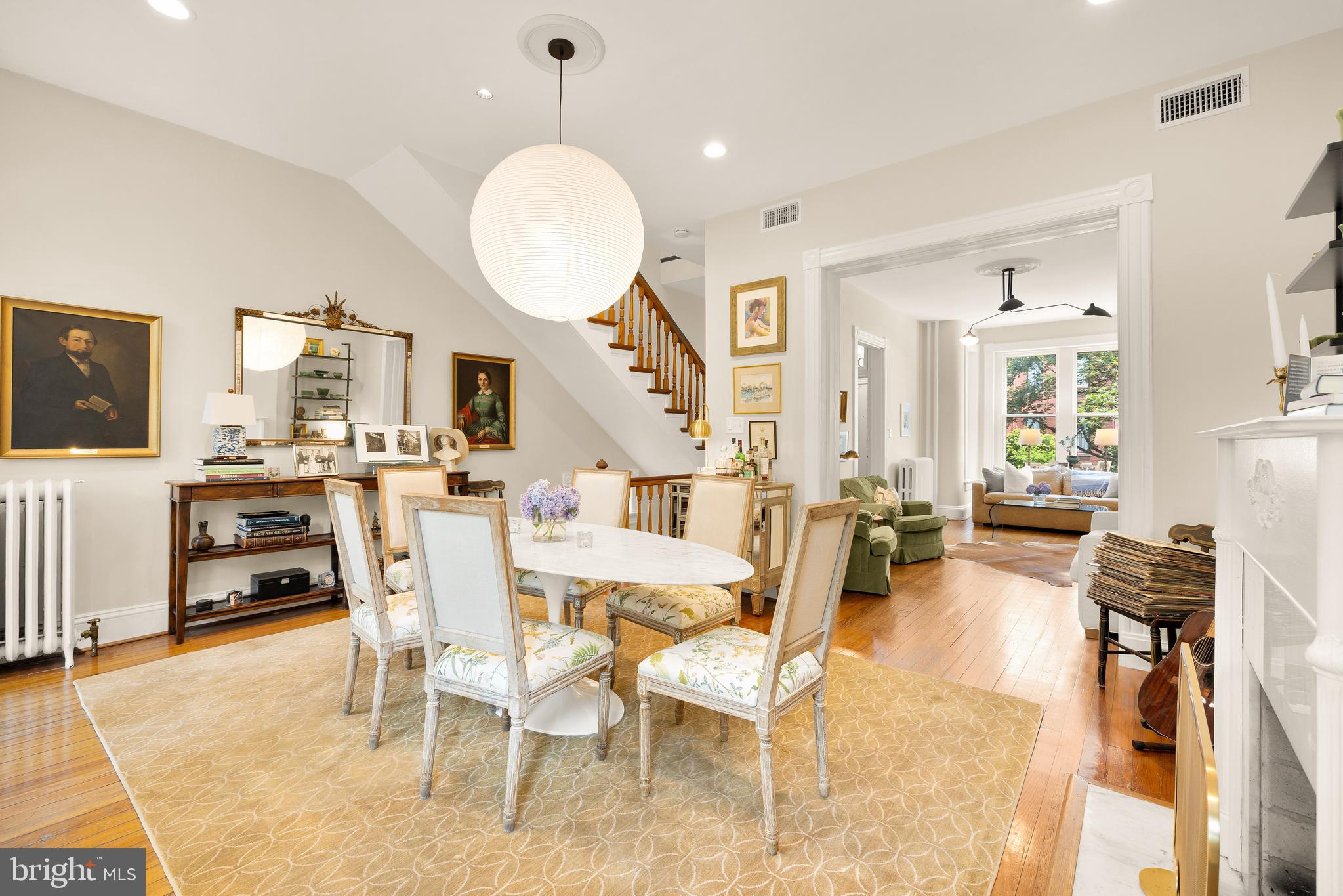 107 5th Street Southeast Washington, DC 20003 - Photo 3 of 26 a view of a dining room and livingroom with furniture wooden floor a rug a fireplace and a chandelier