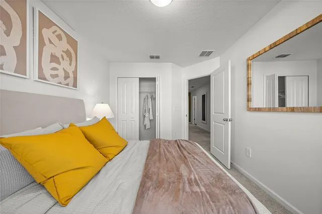 a bedroom with a bed and a painting on the wall