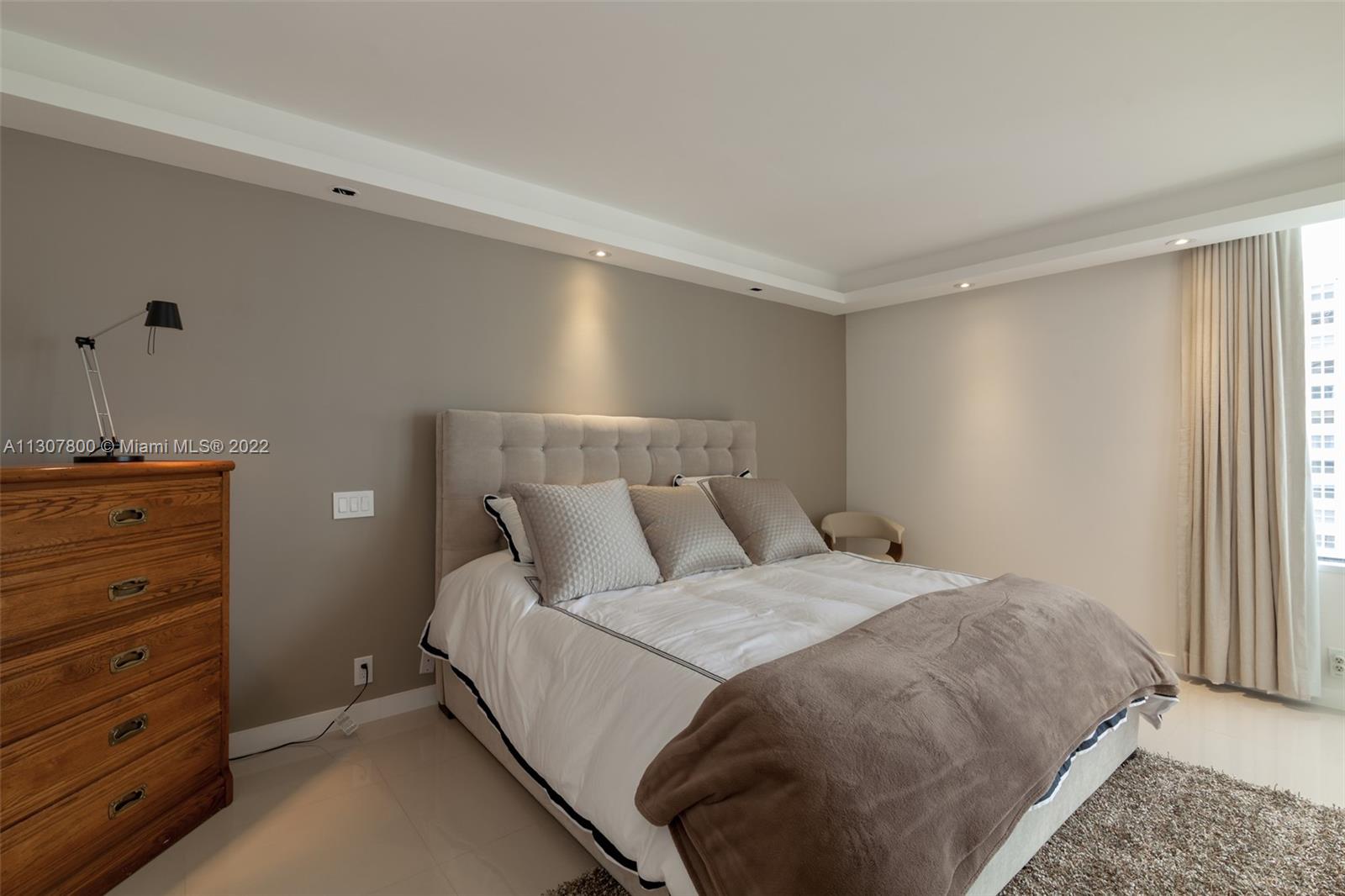 520 Brickell Key Drive, Unit A1603 Miami, FL 33131 - Photo 13 of 27 a bedroom with a bed and a window