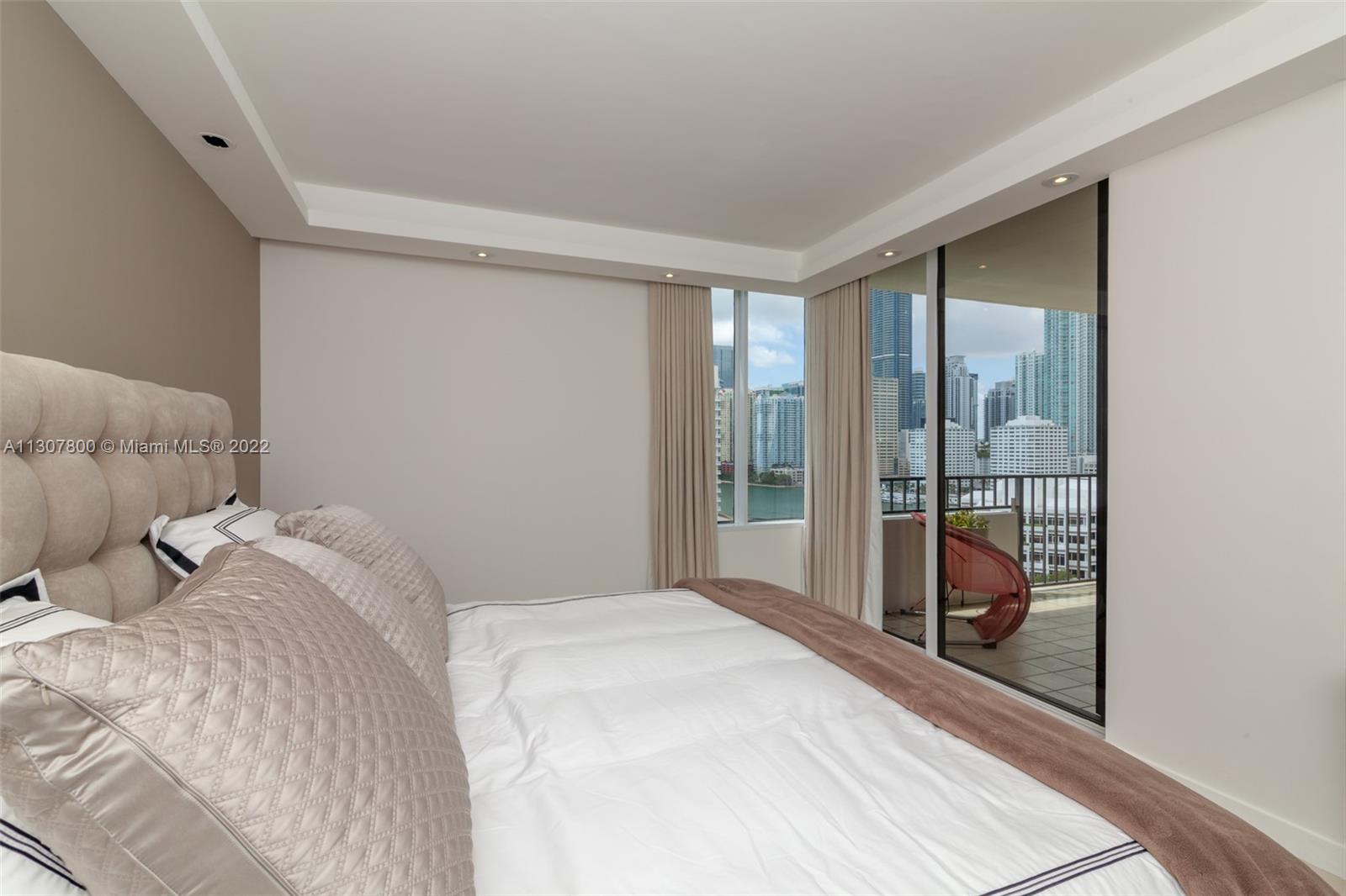 520 Brickell Key Drive, Unit A1603 Miami, FL 33131 - Photo 14 of 27 a bedroom with a bed and a large window