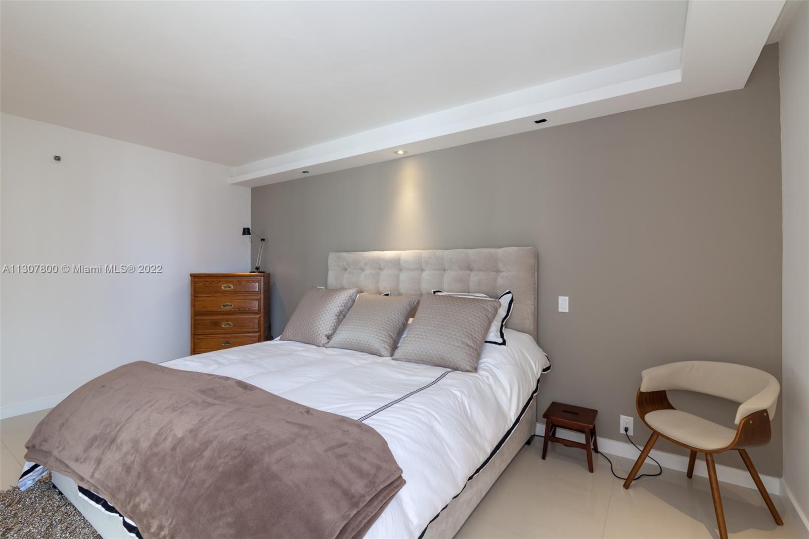 520 Brickell Key Drive, Unit A1603 Miami, FL 33131 - Photo 16 of 27 a bedroom with a bed and chair
