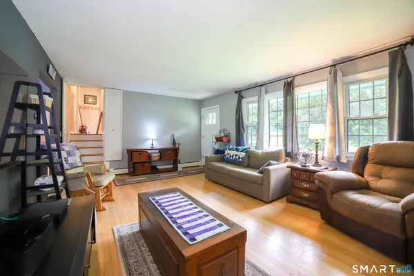 a living room with furniture a flat screen tv and a floor to ceiling window