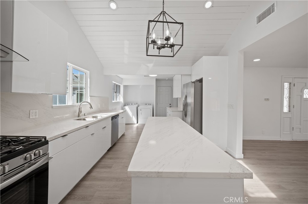 7445 Balcom Avenue Reseda, CA 91335 - Photo 48 of 73 a large white kitchen with lots of counter space and wooden floor