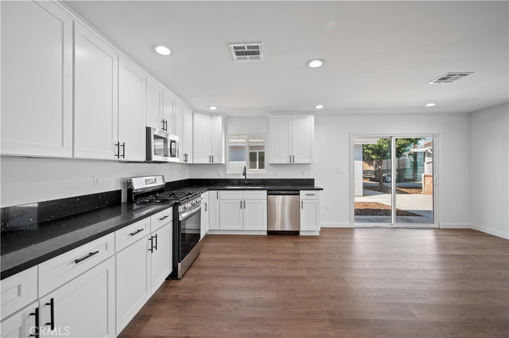 7445 Balcom Avenue Reseda, CA 91335 - Photo 9 of 73 a large kitchen with stainless steel appliances granite countertop a large counter top and a stove with wooden floor