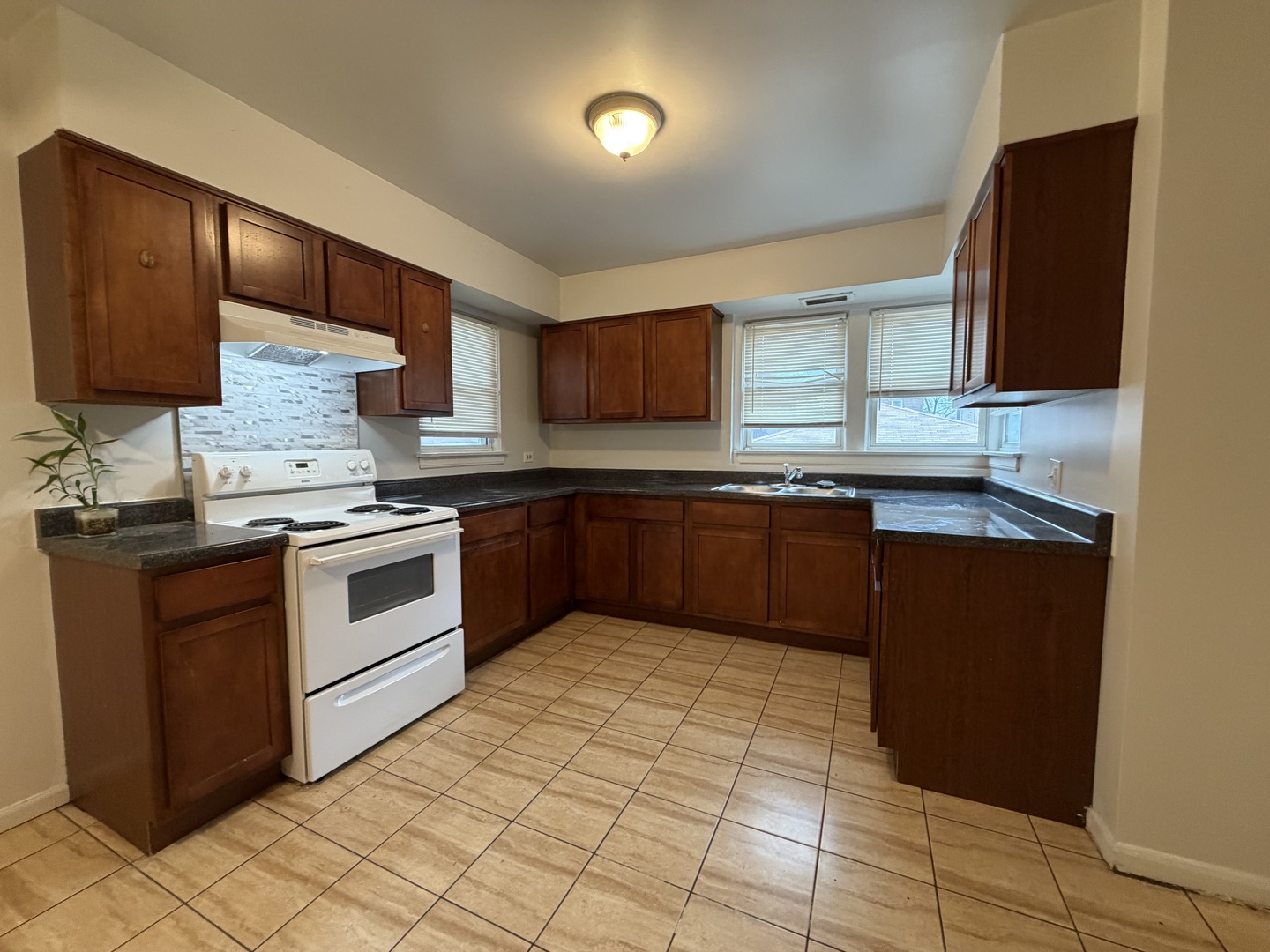 312 East 83rd Street, Unit 1 Chicago, IL 60619 - Photo 11 of 18 a kitchen with stainless steel appliances granite countertop a sink stove and cabinets