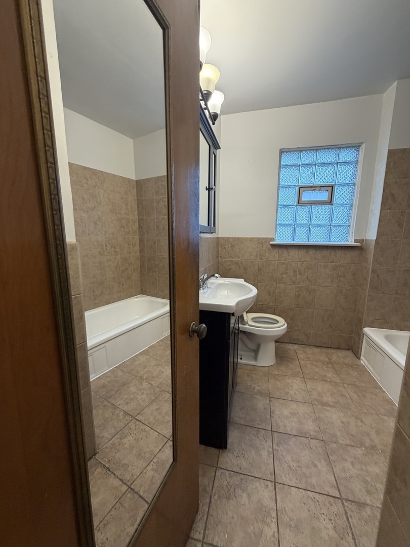 312 East 83rd Street, Unit 1 Chicago, IL 60619 - Photo 16 of 18 a bathroom with a toilet and a shower