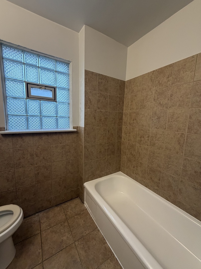 312 East 83rd Street, Unit 1 Chicago, IL 60619 - Photo 17 of 18 a bathroom with a toilet and a bathtub