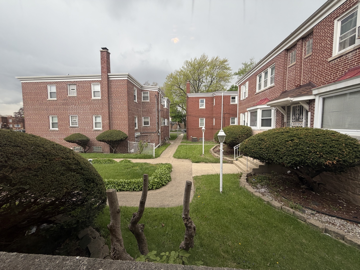 312 East 83rd Street, Unit 1 Chicago, IL 60619 - Photo 2 of 18 a view of a brick house with a yard and plants