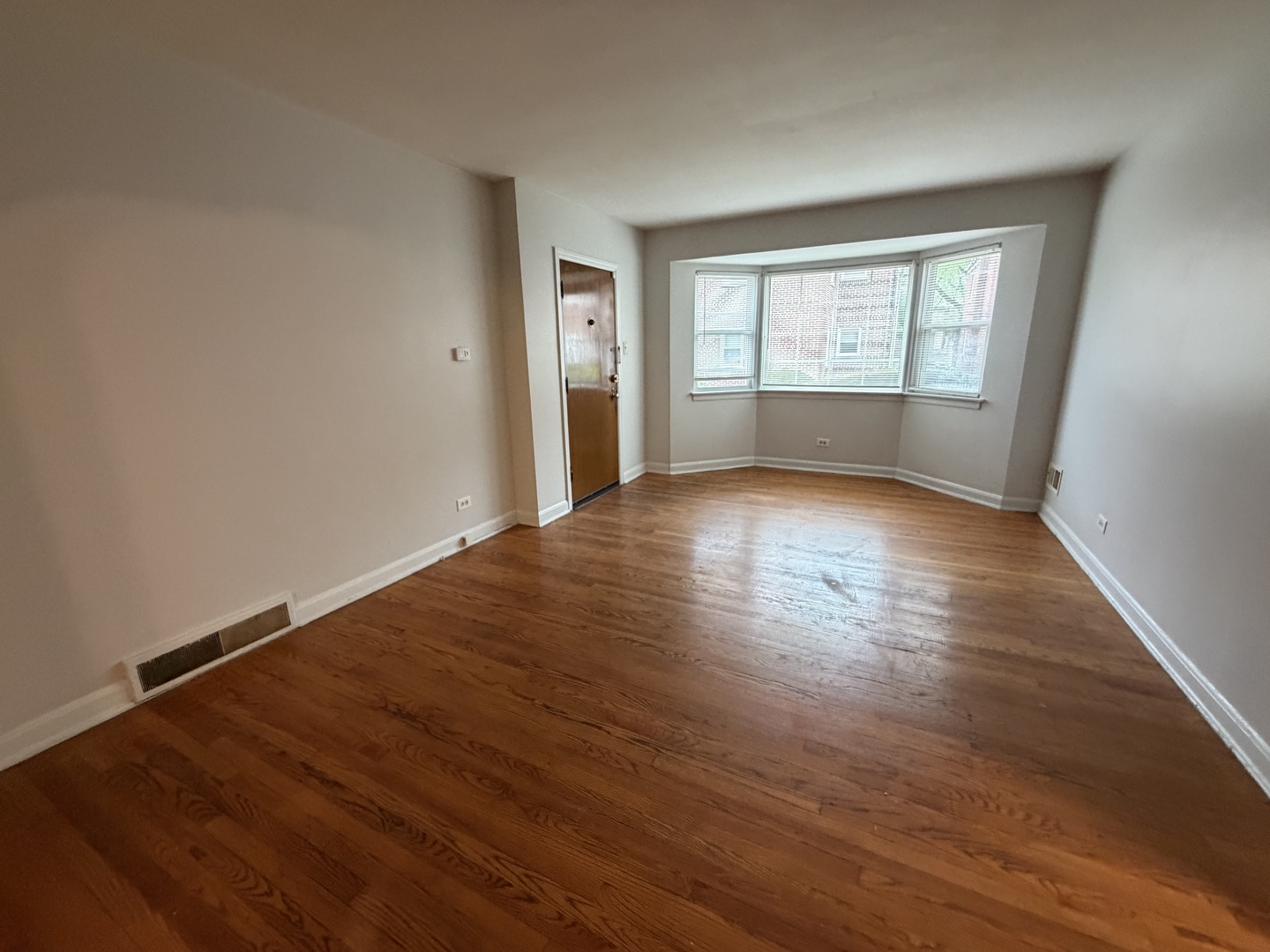 312 East 83rd Street, Unit 1 Chicago, IL 60619 - Photo 6 of 18 a view of an empty room with wooden floor and a window