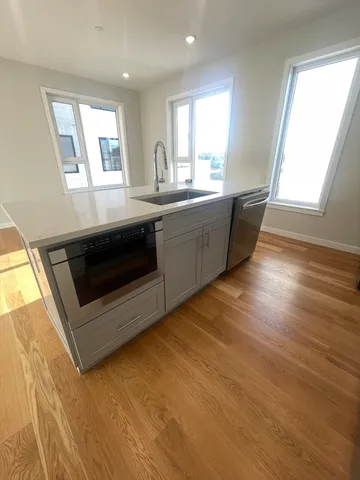 a kitchen with stainless steel appliances kitchen island granite countertop a stove a sink and a microwave