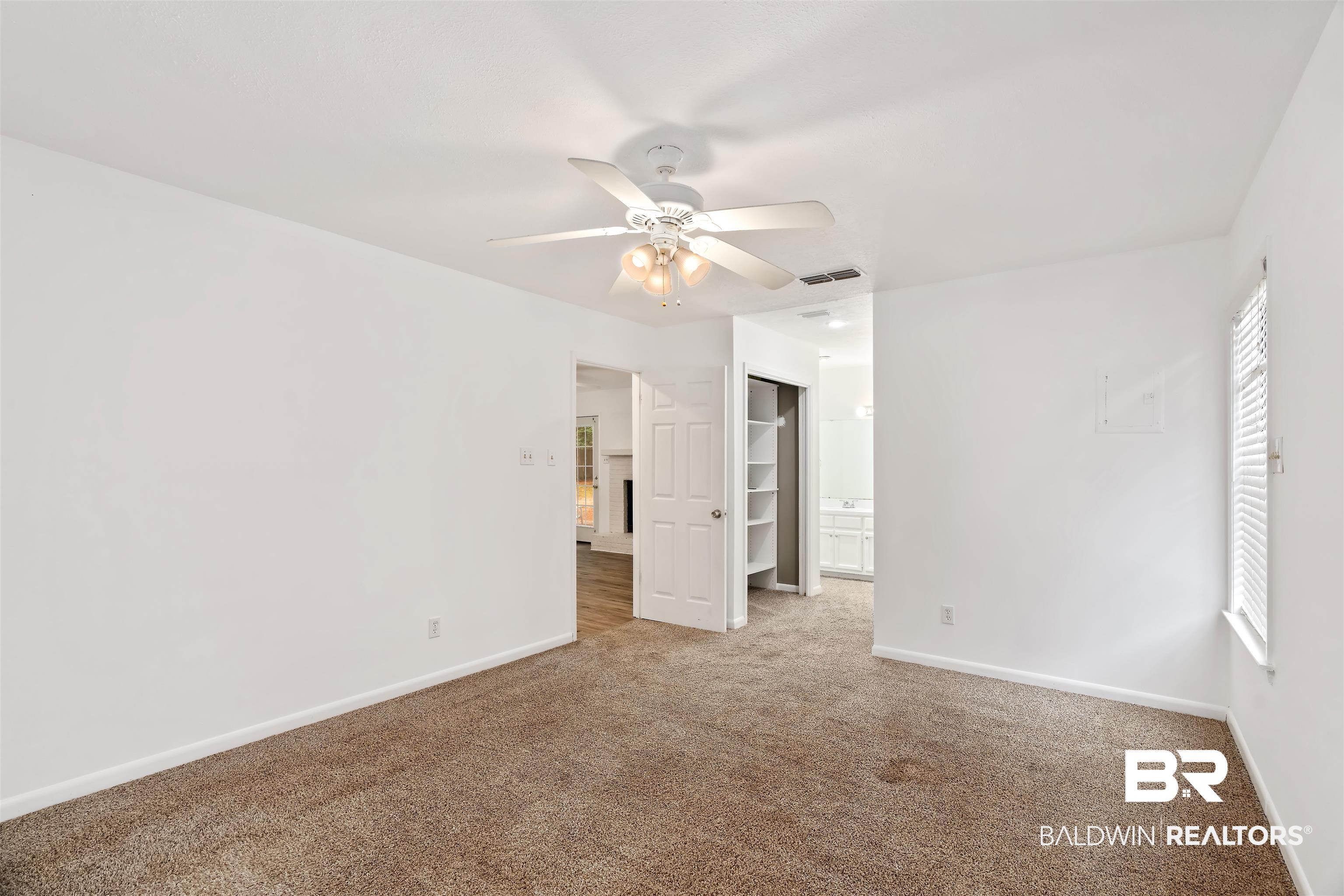 159 Montclair Loop Daphne, AL 36526 - Photo 9 of 18 Unfurnished bedroom with a ceiling fan, carpet flooring, ensuite bath, and a walk in closet