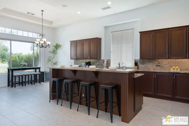 a kitchen with granite countertop a table chairs sink and cabinets