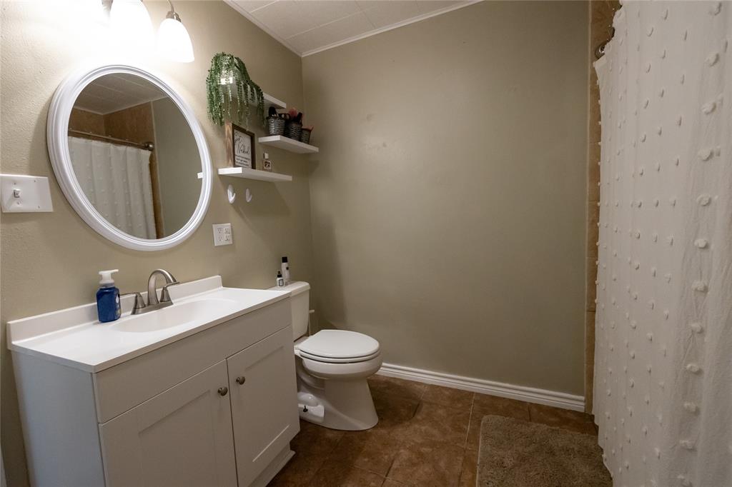 3205 42nd Street Snyder, TX 79549 - Photo 15 of 31 a bathroom with a sink and a mirror