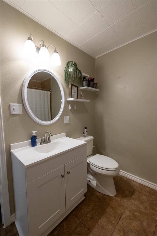 3205 42nd Street Snyder, TX 79549 - Photo 16 of 31 a bathroom with a toilet sink and mirror